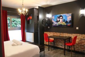 a room with a bed and a tv on a wall at R'Studio Ciné Salle 2 Hypercentre Grenoble in Grenoble