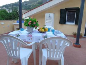 a white table with fruit and flowers on it at Stella Maris Holidays, Large Terrace, 5 min Beach, Amalfi Coast in Maiori
