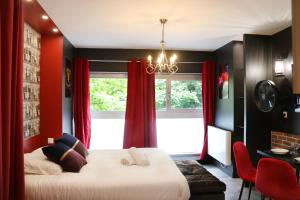 a bedroom with a large bed with red curtains at R'Studio Ciné Salle 2 Hypercentre Grenoble in Grenoble