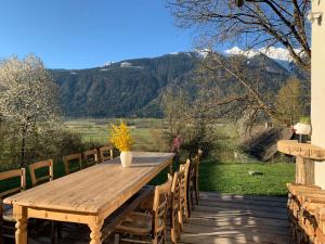 a wooden table and chairs on a deck with mountains at Ferienhaus Krieben 