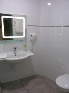 La salle de bains est pourvue d'un lavabo, d'un miroir et de toilettes. dans l'établissement Albizia Beach Hotel, à Varna