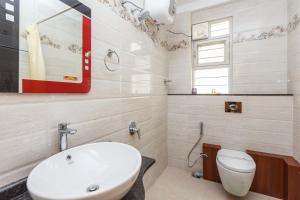 La salle de bains est pourvue d'un lavabo blanc et de toilettes. dans l'établissement BluO 1BHK Koramangala - Terrace Garden, Parking, à Bangalore