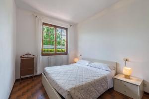 Habitación blanca con cama y ventana en Villa Adi Appartamento 2, en Domaso