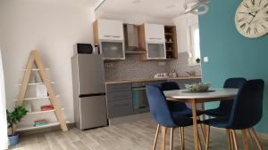 een keuken met een tafel en stoelen en een koelkast bij Urban Apartment Vukić in Trogir