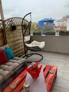 a patio with a couch and a table and a chair at Boulevard Boutique Aparthotel in Korçë