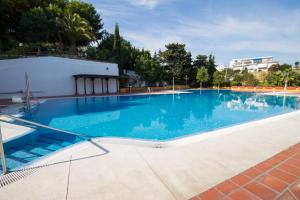 duży basen z niebieską wodą w obiekcie Duquesa 506 by IVI Real Estate w mieście Torremolinos