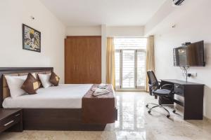 a bedroom with a bed and a desk and a chair at BluO Studio Koramangala - Terrace Garden, Parking in Bengaluru