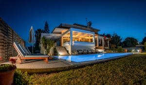 a villa with a swimming pool at night at City Mansion Rhodes in Rhodes Town