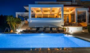 a villa with a swimming pool at night at City Mansion Rhodes in Rhodes Town