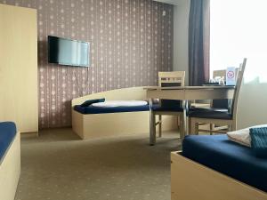 a room with a table and a tv on a wall at Žilina in Marijampolė