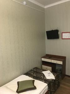 Habitación con cama y TV en la pared. en Hotel Akkerman en Oryol
