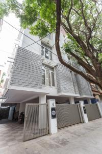 a large white house with a fence in front of it at BluO Studio Koramangala - Terrace Garden, Parking in Bengaluru
