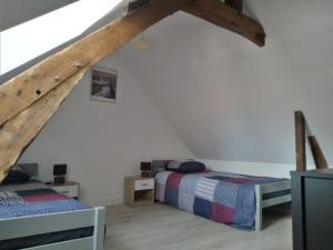 a attic room with two beds and a ladder at L'abbevilloise, aux portes de la Baie de Somme in Abbeville