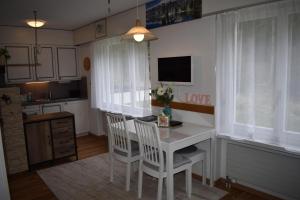 a kitchen with a table and chairs and a tv at Seegarten B (168 Be) in Lenzerheide