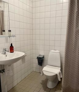 Baño blanco con aseo y lavamanos en HOTEL N Hostel Malmö City, en Malmö