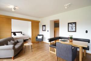 ein Wohnzimmer mit einem Sofa und einem Bett in der Unterkunft Hotel Berghof in Seefeld in Tirol