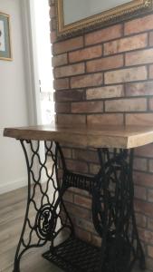 a wooden table in front of a brick wall at Apartament Gościnne Sady in Malbork