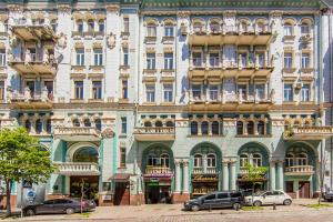 a large building with cars parked in front of it at Поруч укриття, 2к квартира біля Хрещатика, вхід у метро у сусідньому будинку in Kyiv