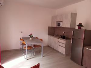 a kitchen with a table and chairs and a refrigerator at Residence Carlo in Grado
