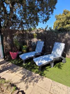 twee stoelen en een tafel in de tuin bij LE MIRABILIS in La Motte