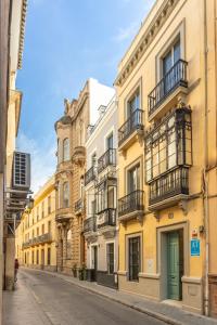 a row of yellow buildings on a street at Kayser Premium Suites in Seville