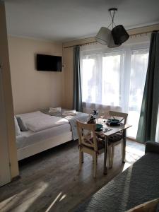 a bedroom with a bed and a table and chairs at apartamenty Orla in Międzyzdroje