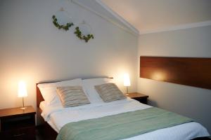 a bedroom with a large bed with two lamps at Pokoje Bakos Radocza in Radocza