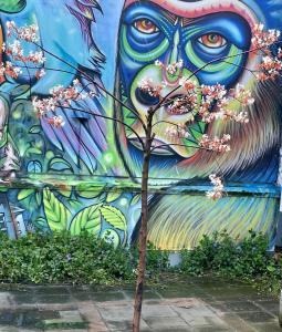 a wall with a tree in front of a mural at HOTEL N Hostel Malmö City in Malmö