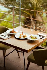 een houten tafel met borden eten en wijnglazen bij Hotel La Culla Del Lago in Castel Gandolfo