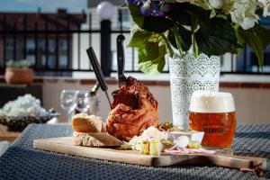 a turkey on a cutting board next to a glass of beer at Penzion a restaurace Feldsberg in Valtice