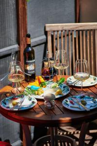 a wooden table with wine glasses and food on it at Apartment Borna in Cavtat