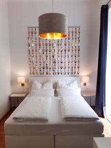 um quarto com uma grande cama branca e luz natural em Apartment-Zimmer KRISTALL - großer Balkon und Parkplatz direkt im Zentrum em Bad Ischl