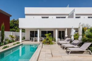 a villa with a swimming pool and a house at Villa Deluxe Suites Maspalomas in Maspalomas