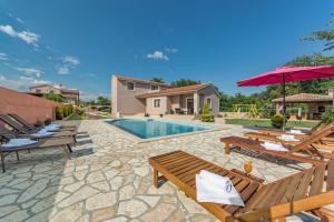 a patio with chairs and a swimming pool at Villa Klaudia in Valtura