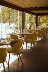 un comedor con mesas, sillas y ventanas en Hotel La Culla Del Lago en Castel Gandolfo