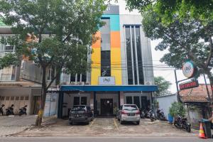 a building with cars parked in front of it at Sans Hotel Cihampelas Bandung in Bandung