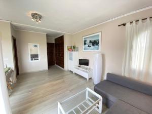 sala de estar con sofá y TV en El Palmar, en Denia