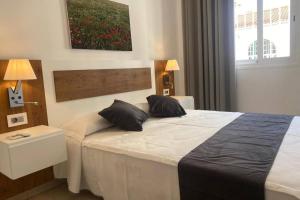 een slaapkamer met een bed met twee kussens erop bij Kalma IV in La Restinga