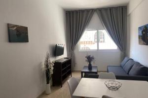 een woonkamer met een blauwe bank en een tafel bij Kalma IV in La Restinga