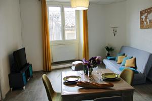 a living room with a table and a couch at Appartement le Mimosa - Apparts Cosy in Villeneuve-de-Berg