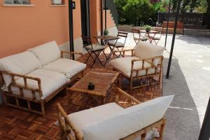eine Terrasse mit Stühlen, einem Sofa und Tischen in der Unterkunft Roccia Bianca in Syrakus