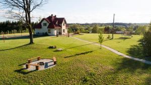 ein großer Hof mit einem Haus und einem Spielplatz in der Unterkunft Perła Rospudy in Filipów