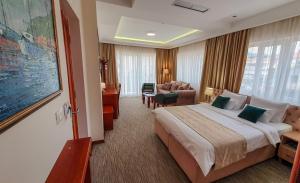 a hotel room with a bed and a living room at Hotel Montenegrino in Tivat