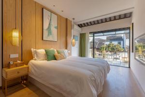 苏州Tongli Slowlife River View Inn的一间带大床的卧室和一个阳台