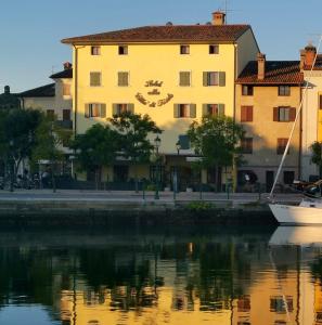 a building with a heart sign on the side of the water at Hotel Alla città di Trieste in Grado