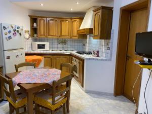 eine Küche mit einem Tisch und einem weißen Kühlschrank in der Unterkunft Casa vacanza da Paola in Trapani