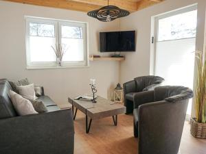 a living room with two couches and a coffee table at Ferienhaus Sonnenufer in Rheinsberg