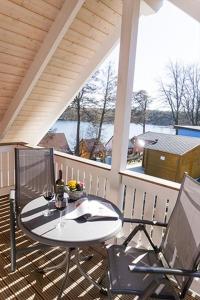 een patio met een tafel en 2 stoelen op een veranda bij Ferienhaus Sonnenufer in Rheinsberg