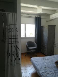 1 dormitorio con 1 cama, 1 silla y 1 ventana en Cath's place en Toulon