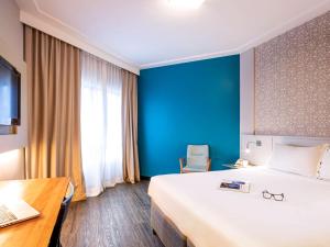 um quarto de hotel com uma cama grande e uma secretária em Mercure Florianópolis em Florianópolis